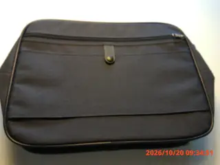 Samsonite taske i sort stof med lynlås rundt om.