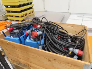 Palle med kraftforlængerkabler, byggepladstavle, varmeblæsere m.m.