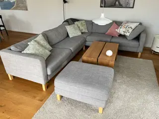 Hjørnesofa med puffe i lys grå stof.