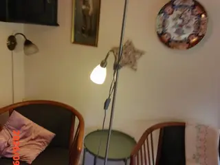 Fin gulvlampe i børstet metal med rund fod.