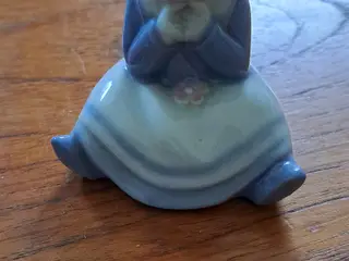 Siddende pige i porcelæn den er uden mærke,