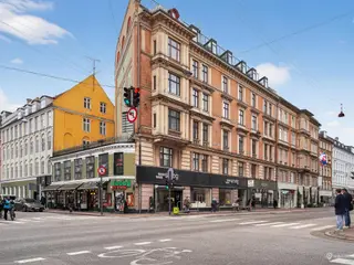 Bred facade med stort skilt og masser af kundetrafik