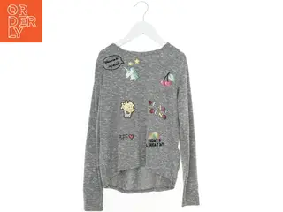 Grå bluse med farverige illustrationer fra H&M (str. 146)
