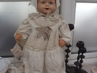 Gammel babydukke i gammel tøj
