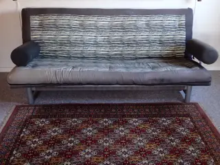 Sovesofa FUTON med armlæn og magasin.