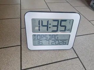 Ur med ugedag, dato og årstal. Store tydelige tal.