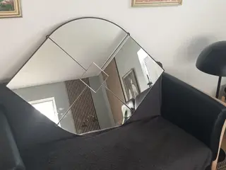 Spejlglas monteret på oval plade.