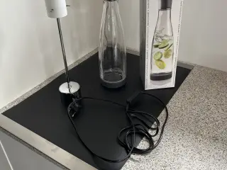 Herstal lampe og en vandkaraffel med låg og æske. 