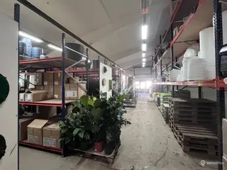 Stor hal med med ledhejseport. kontor, køkkenfaciliteter og toilet med bad.