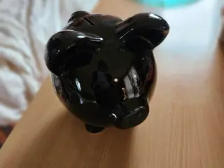 Sort sparegris med intakt prop i bunden