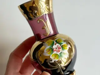 Lilla glas med gulddeko og blomst