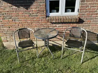 Lille rundt cafébord med rillet glasplade og metal
