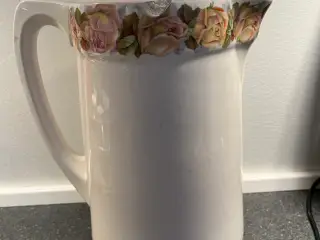 Flot antik kande med dekorativ blomsterkant med fe