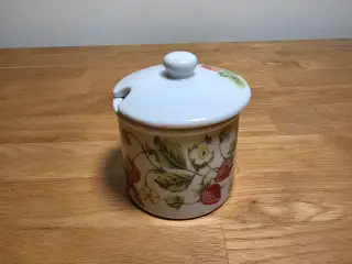 Fin lille marmeladekrukke med låg og jordbærprint.