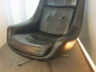 Sort lænestol i skind/læder med fempas dreje fod